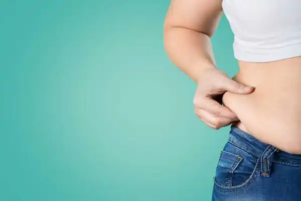 Image of woman pinching her love handles to show weight gain Corstorphine